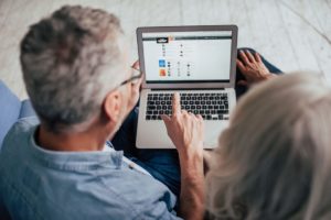 older couple on computer researching how to choose the right senior living community