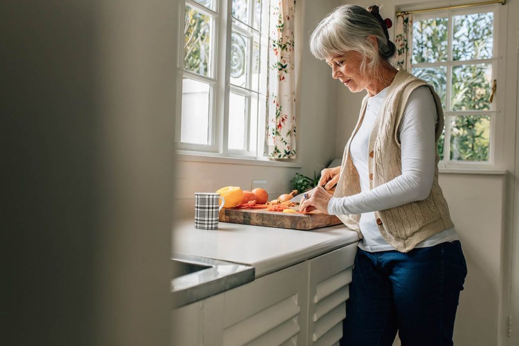 older woman making lunch and enjoying her independent senior living