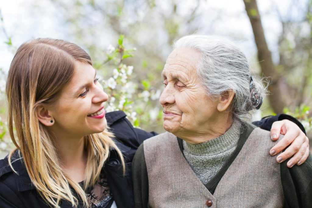 adult daughter and elderly mother hugging learning how to determine level of care for seniors