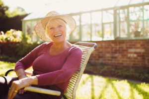 senior woman wearing a hat in the sun representing summer safety tips for seniors