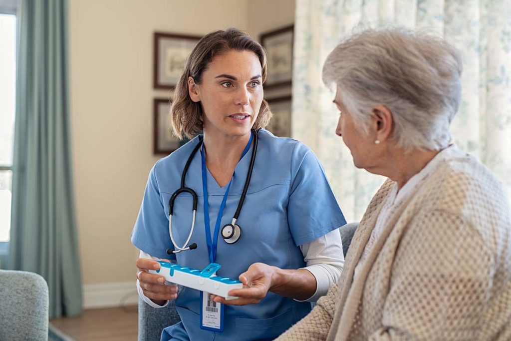 woman doctor talking to her senior patient about differences of assisted living vs nursing home