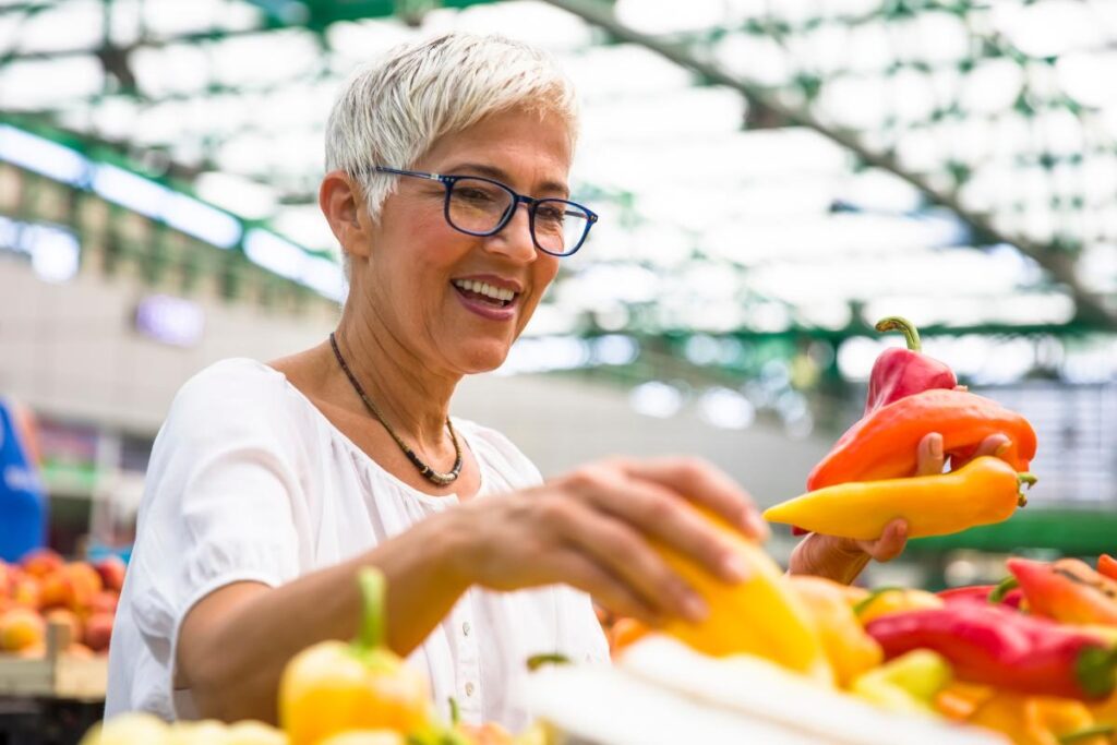 a senior chooses peppers, one of the healthy foods all seniors should be eating