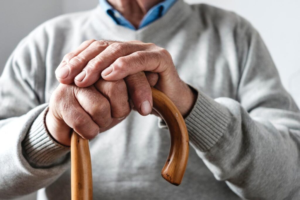 a senior holds a cane in anticipation of someone picking them up for things to do with seniors