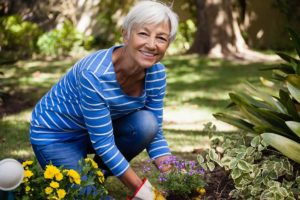 a senior woman is outside participating in gardening for seniors activities