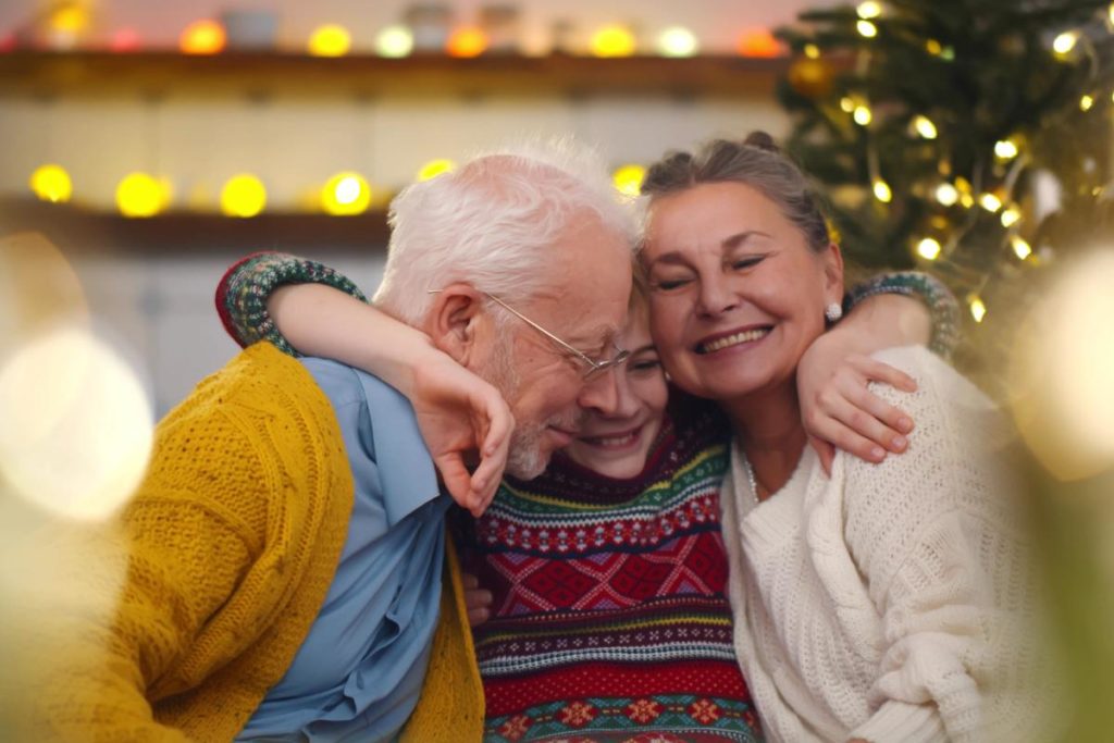 a family hugs during a celebration after creating new year's resolution ideas for senior family members