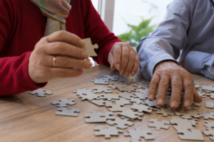 seniors in memory care work on a stimulating puzzle together