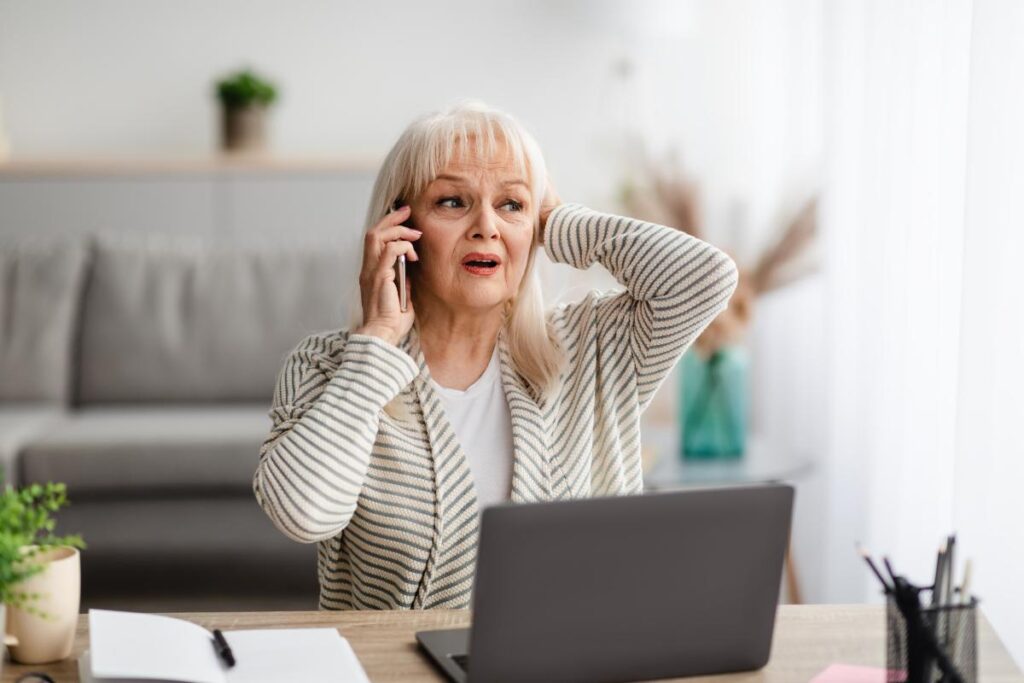 a senior on the phone looks worried possibly after realizing they fell for one of many financial scams targeting seniors