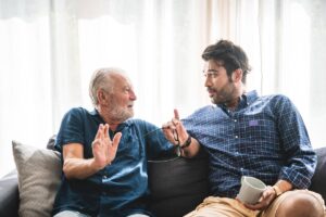 an adult child has a tense conversation with a senior parent, an example of seniors refusing care