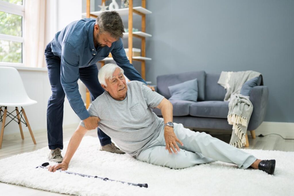 a n adult child helping a senior off the floor, one of the first things to learn after a senior falls