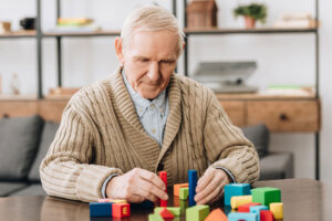 a person stacks blocks while doing brain exercises for seniors