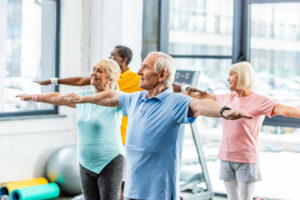 a group in a fitness class practices balance exercises for seniors