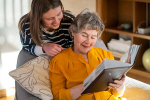 a senior parent reads a book about Respite Care while an adult child looks over their shoulder