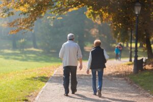 two seniors walk outside after learning the importance of being active as a senior