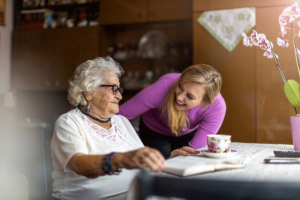 a nurse helps a senior at a desk after answering how long does respite care last?