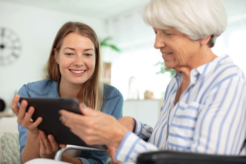 a nurse helps a senior with a tablet after answering how much is senior memory care?