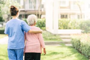 a nurse and senior stand and talk about Practices for Senior Living Transportation Services