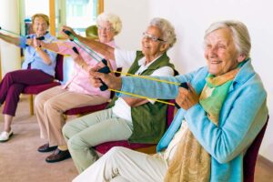 A group of women sitting together and participating in a senior fitness challenge and staying active together.