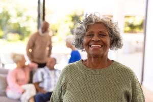 A senior woman smiles as she spends time with friends and feels a sense of purpose in senior living.