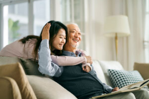 A granddaughter who understands the importance of family in senior care gives her grandfather a hug.