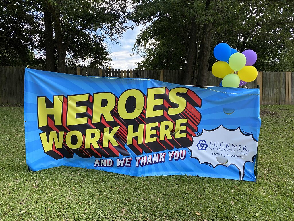 large blue sign that says "heroes work here"